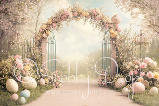 Pastel floral garden gate arch backdrop with roses, birdcages, and speckled Easter eggs.